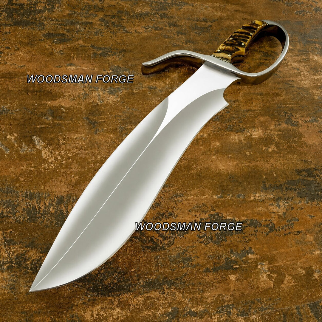 A curved silver steel dagger or knife with a textured brown and gold hilt, displayed diagonally on a rustic brown wooden background. The brand name &