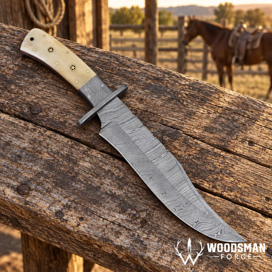 A custom fixed-blade knife with a Damascus steel blade and a cream-colored bone handle, resting on a rustic wooden fence post with a blurred western ranch background featuring a horse. The &