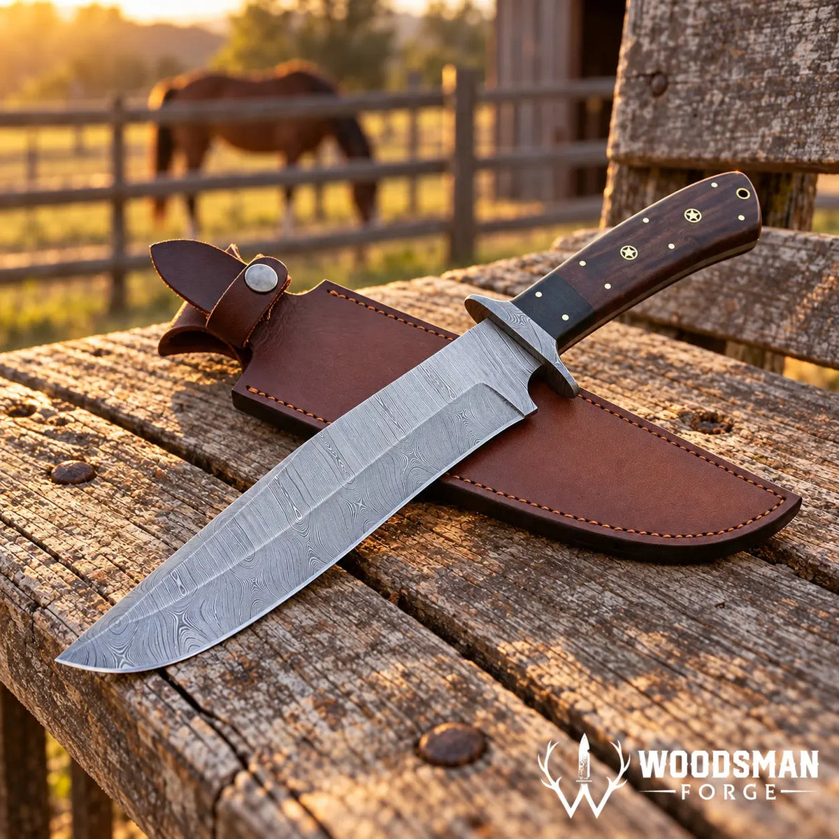 A fixed-blade knife with a patterned steel blade and dark wood handle rests on a brown leather sheath on a rustic wooden table outdoors. A horse and fence are blurred in the background at sunset.