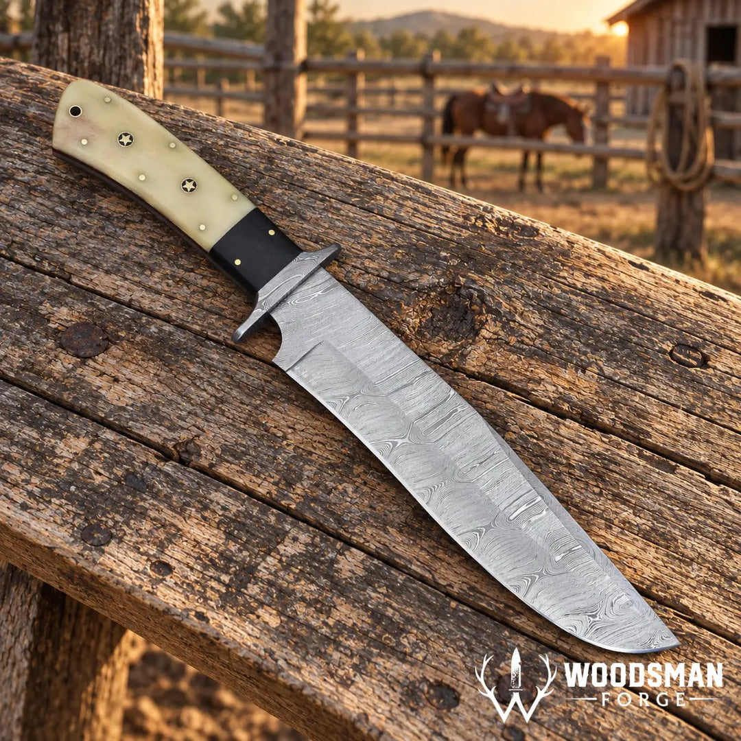 A large fixed-blade knife with a patterned steel blade and a cream-colored handle with black grip and brass pins, resting diagonally on a rustic wooden fence rail in an outdoor ranch setting with a horse in the background. The &